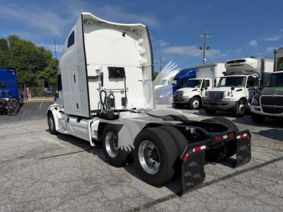 Peterbilt 579 tractor sleeper cab rear view showing fifth wheel and rear tires with chrome wheels.