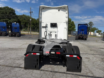 Peterbilt 579 tractor cab rear view showing fifth wheel and dual rear axles with mudflaps and white sleeper/cab area.