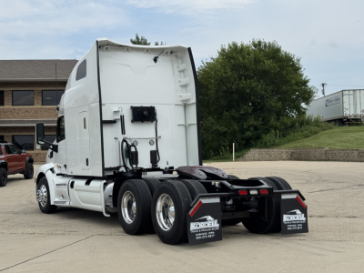 Peterbilt 579 rear view showing tractor and dual rear axles, white cab, fifth-wheel area, mud flaps