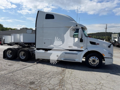 Peterbilt 579 semi-truck in a side view, white cab with sleeper, six-wheel tractor (2 rear axles), no visible branding other than general truck features.