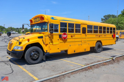 Yellow Blue Bird Vision school bus side view with stop sign and door, markings and windows visible