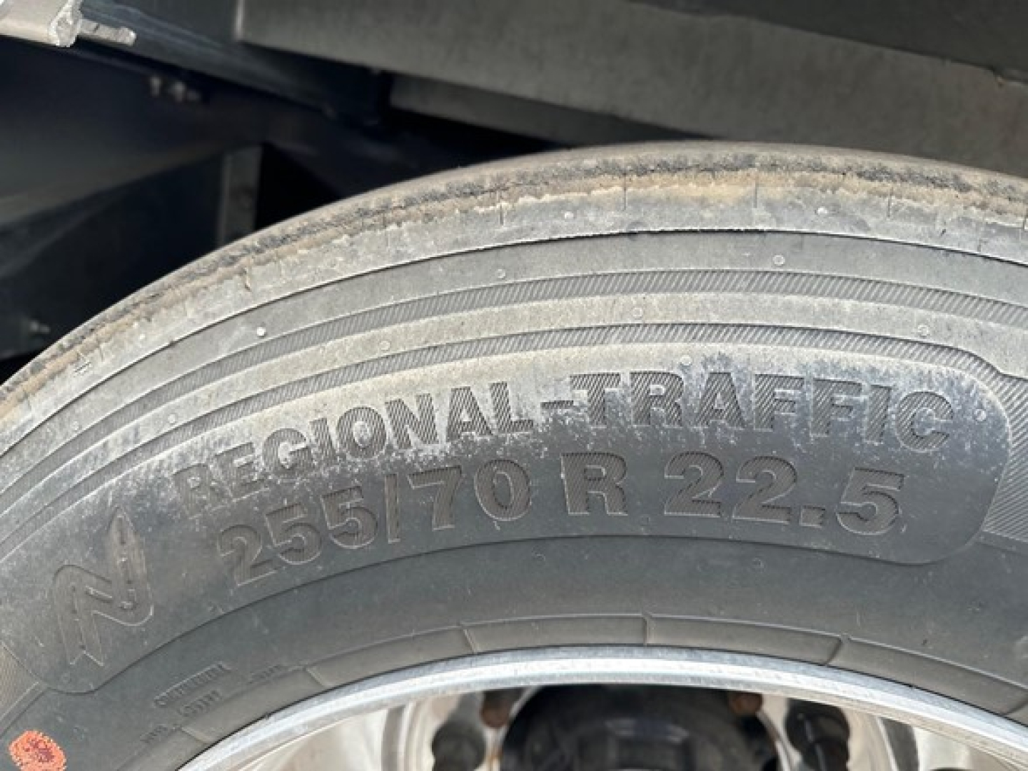 Trailer wheel and tire showing Regional Traffic 255/70 R22.5 tire on alloy rim under Manac combo drop deck trailer.