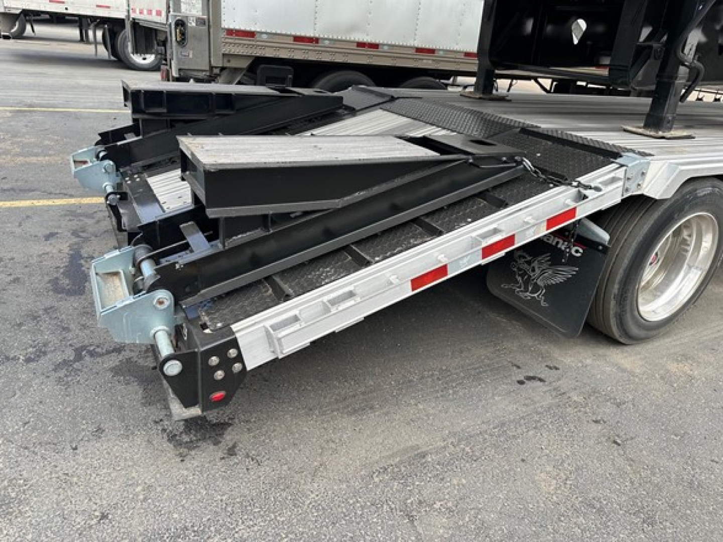 Manac combo drop deck trailer viewed from rear side showing extendable ramp and loading deck components with black and silver finish.