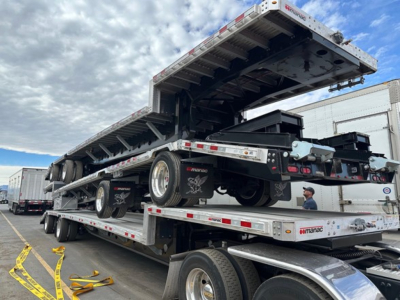 Manac combo drop deck trailer loaded on a multi-axle trailer with side rails and hydraulic tilt sections.