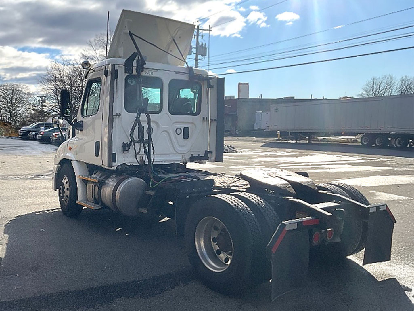 2017 Freightliner Cascadia113 truck chassis and cab view from rear passenger side showing sleeper cab and fifth wheel area.