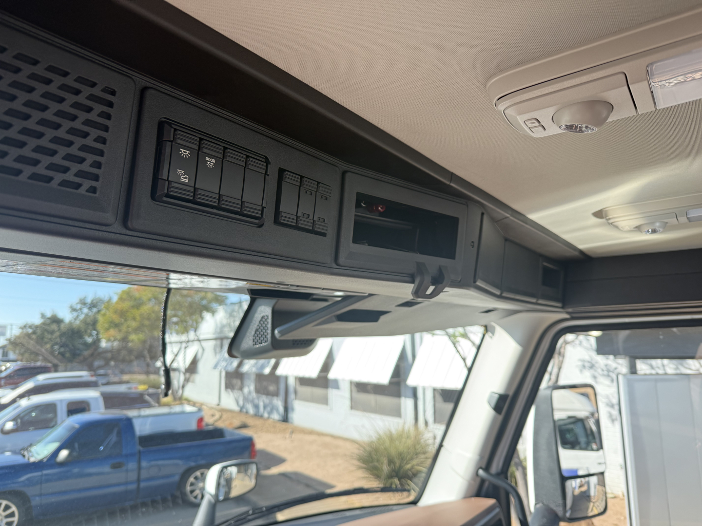 Cab interior overhead panels showing switches and storage compartments in a Mack PR64T truck cab.
