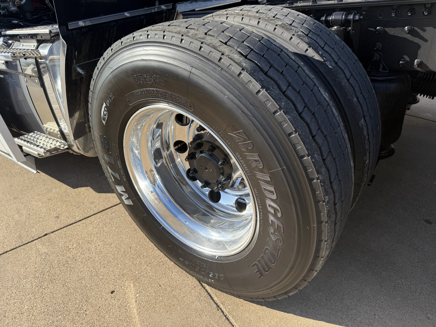Front wheel and tire of a 2026 Mack PR64T conventional daycab showing radial tires and polished chrome wheel.