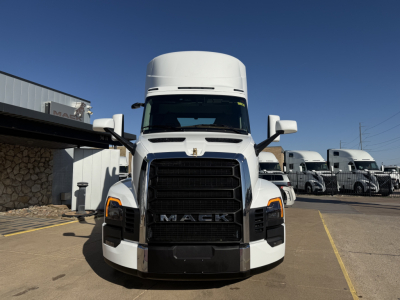 Front view of a white 2026 Mack PR64T truck showing large black grille with MACK emblem, headlights, and side mirrors.