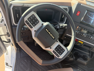 Mack PR64T truck interior showing steering wheel with mounted controls and dashboard displays.