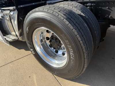 Front wheel and tire of a 2026 Mack PR64T conventional daycab showing radial tires and polished chrome wheel.