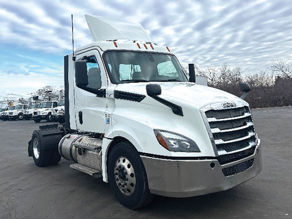Truck cab showing Freightliner Cascadia 126 with white exterior, chrome grille, sleeper panel, and front fuel tanks.
