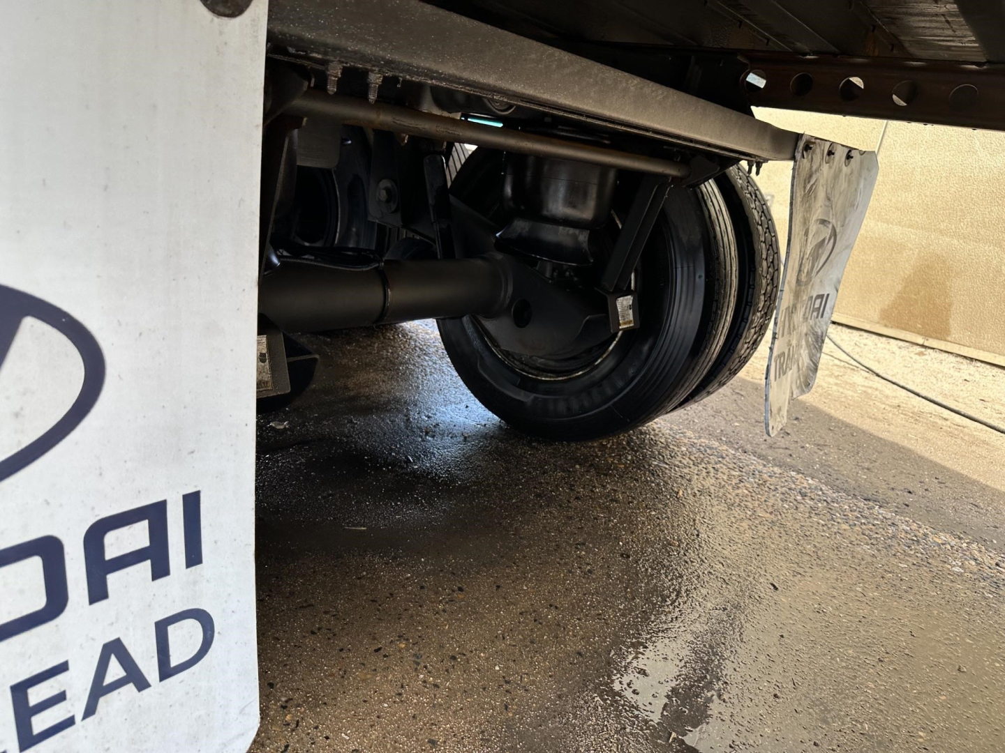 Rear underside of a Hyundai trailer showing suspension, axle, and wheel with mud flap