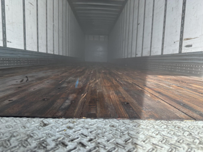 Trailer interior showing wooden floor and metal side walls of a Hyundai air ride dry van with rear swing doors.