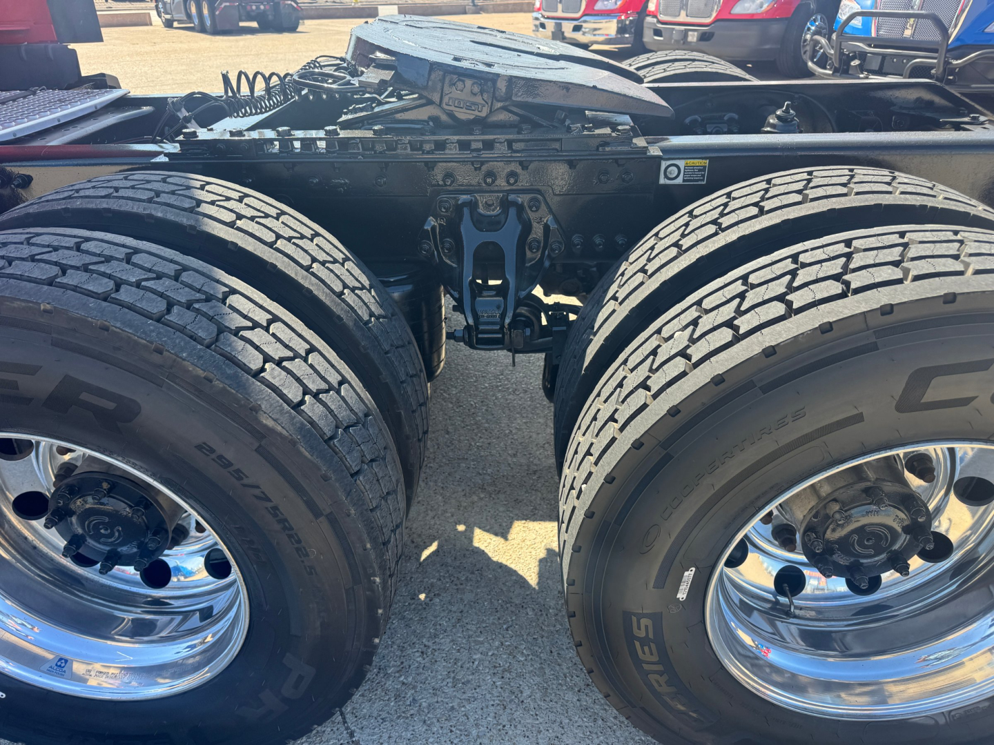 Kenworth T680 truck chassis showing dual rear axles and tires, wheel rims, and undercarriage components.