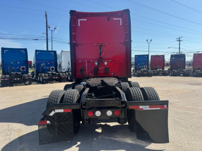 Kenworth T680 rear view showing dual rear axles, fifth wheel, and mud flaps in a truck lot.
