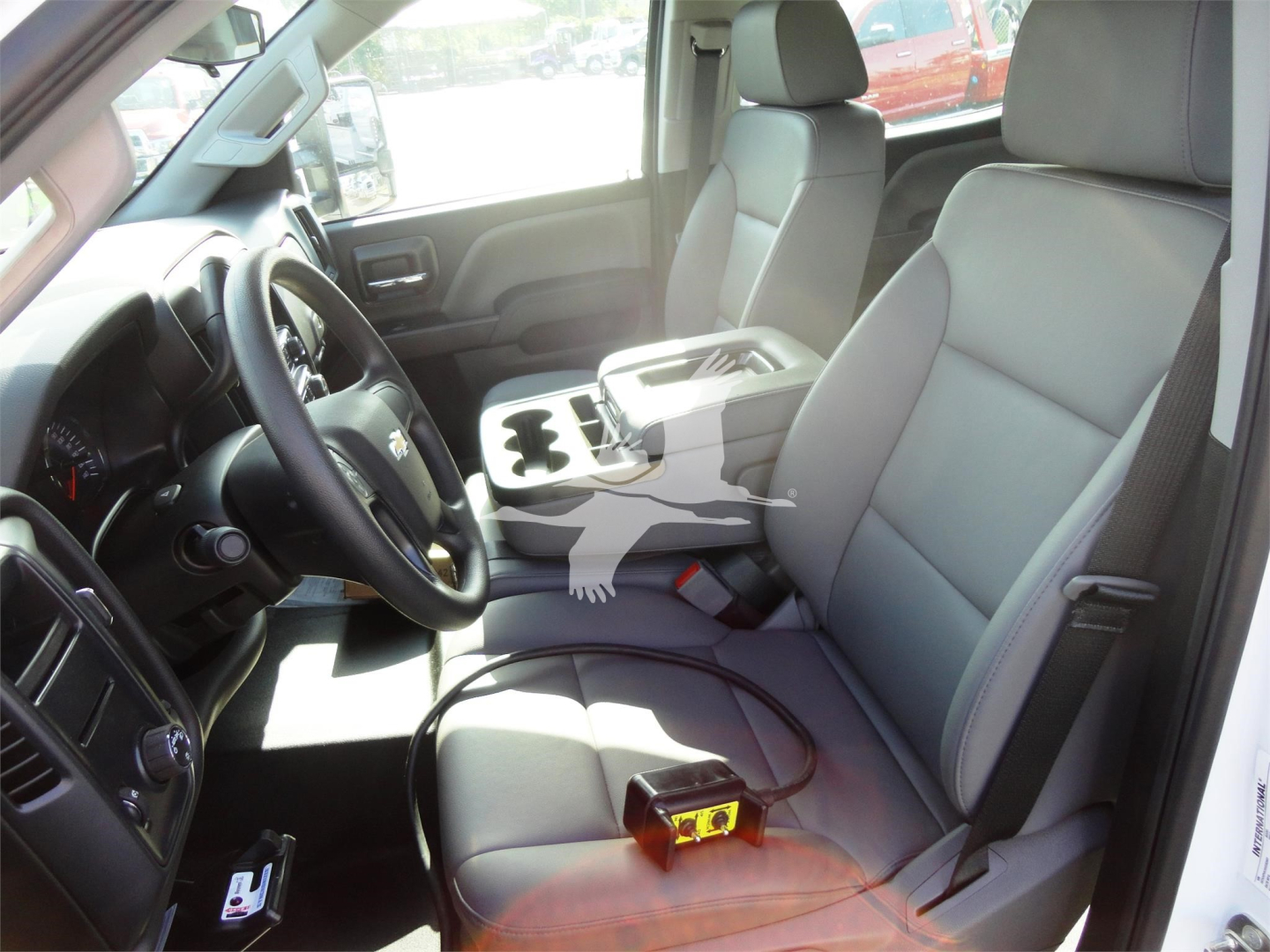 Interior view of a 2023 Chevrolet Silverado 5500HD front cabin showing driver and passenger seats, center console with cupholders, and steering wheel.