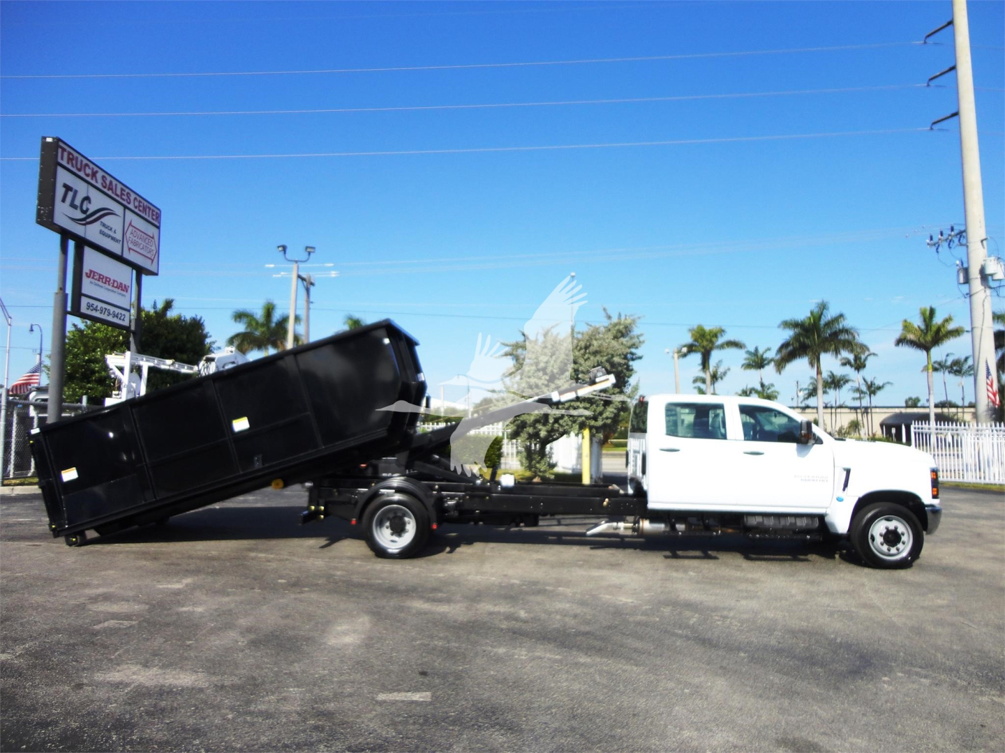 2023 Chevrolet Silverado 5500HD rollover truck in showroom with white cab and black dumping bed, stock J82601