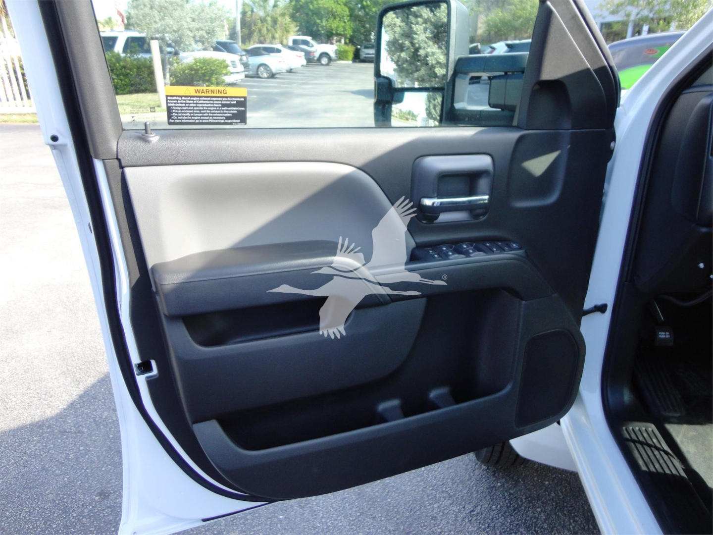 Truck interior door panel showing window controls and storage pocket; partial side mirror visible.