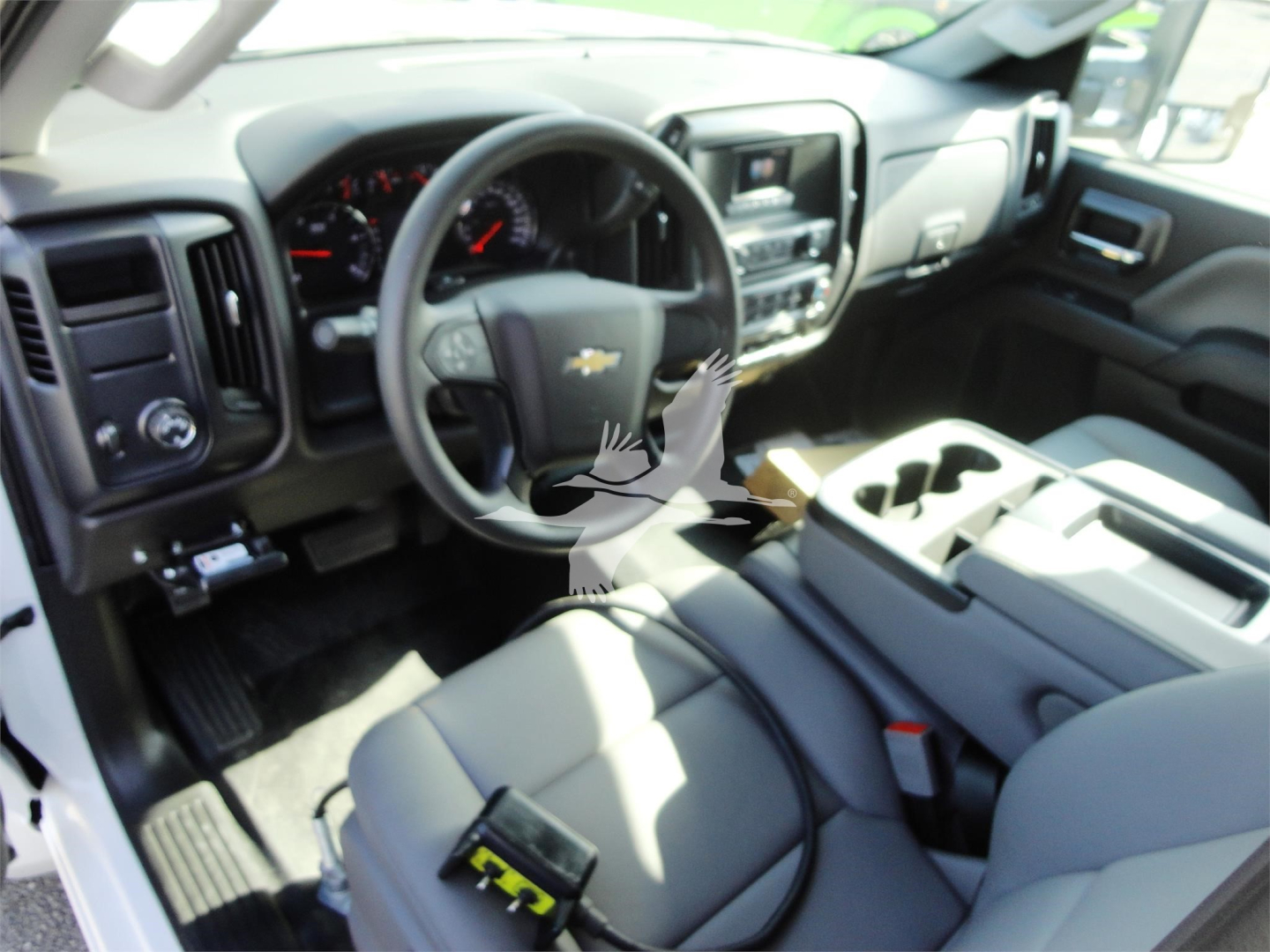 Chevrolet Silverado 5500HD interior showing steering wheel with Chevy emblem, dashboard, center console, and front seats.