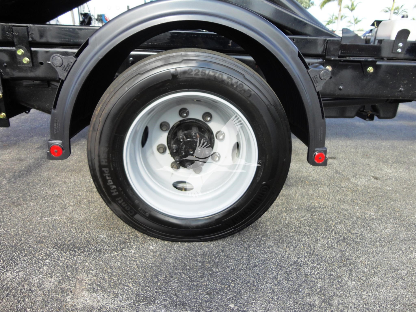 Chevrolet Silverado 5500HD wheel and fender view showing single rear axle with wheel and tire, black chassis, and red reflectors.