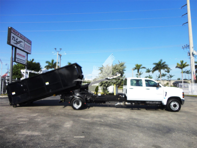 2023 Chevrolet Silverado 5500HD rollover truck in showroom with white cab and black dumping bed, stock J82601