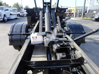 Rear view of Chevrolet Silverado 5500HD rolloff truck chassis showing dual rear axles and hydraulic components.