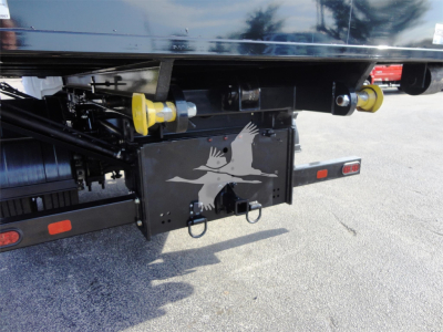 Rear view of 2023 Chevrolet Silverado 5500HD rolloff truck showing rear bumper, yellow towing pins, and a black tail device with a white bird graphic.