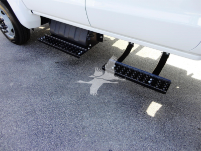 Truck side view showing dual perimeter steps under the cab of a 2023 Chevrolet Silverado 5500HD with stock number J82601.