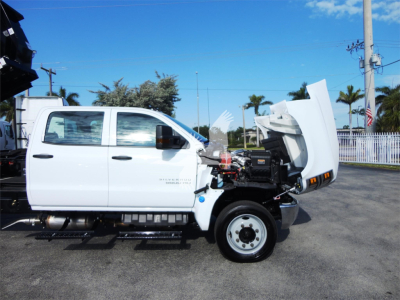 2023 Chevrolet Silverado 5500HD truck side view with hood open showing front engine bay and roll-off bed components.