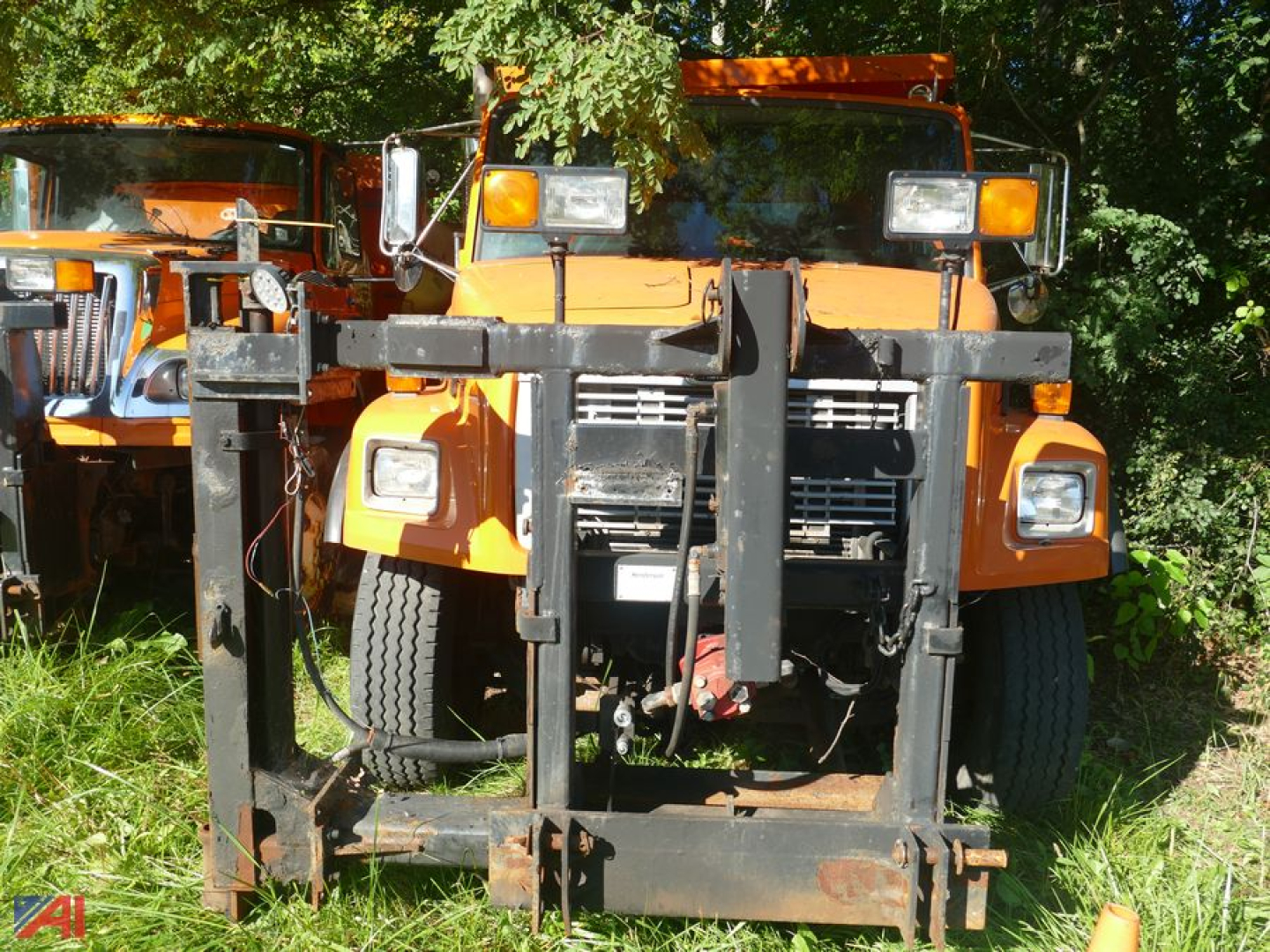 Truck front view of a 2003 Freightliner FL80 dump truck with a heavy front hitch and dual headlights.