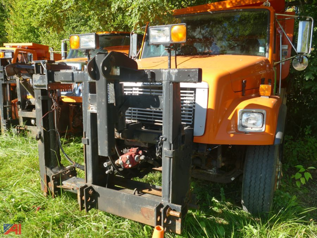 Front view of a 2003 Freightliner FL80 dump truck showing heavy-duty front hitch and grille with orange cab and side mirrors.