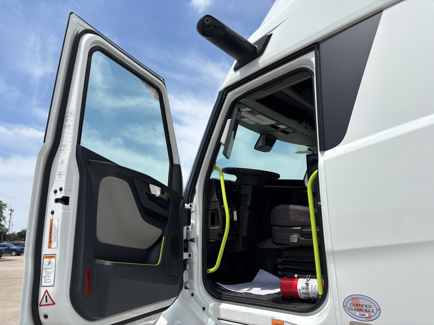 Volvo VNL64T860 sleeper cab truck with open door showing interior and yellow grab handles.