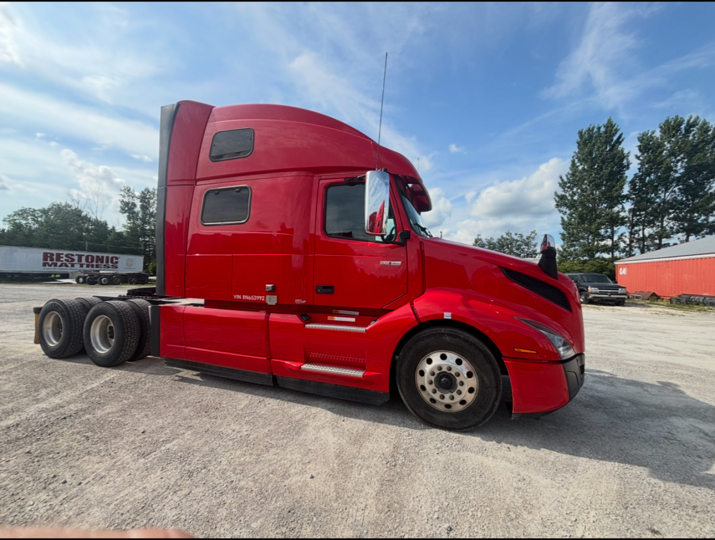 Volvo VNL64T860 semi-truck cab in red profile view showing sleeper and front wheel, side text not legible.
