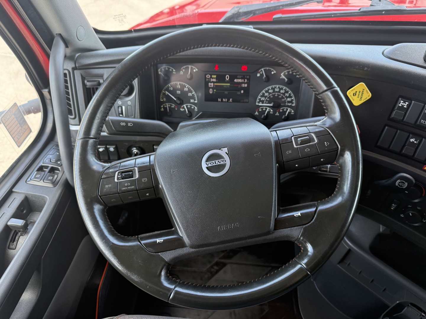 Volvo VNL64T860 steering wheel and dashboard view inside cab with steering wheel controls and instrument cluster.