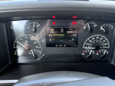 Dashboard of a 2024 Volvo VNL64T860 showing digital gauge cluster and warning lights, with MPH/ RPM gauges and battery/engine indicators.