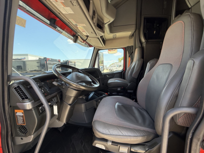 Volvo VNL truck interior showing steering wheel, driver seat, and dashboard from the cab entrance.