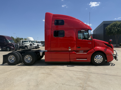  Volvo VNL64T860 tractor in red side view showing sleeper cab and rear wheels with chassis.