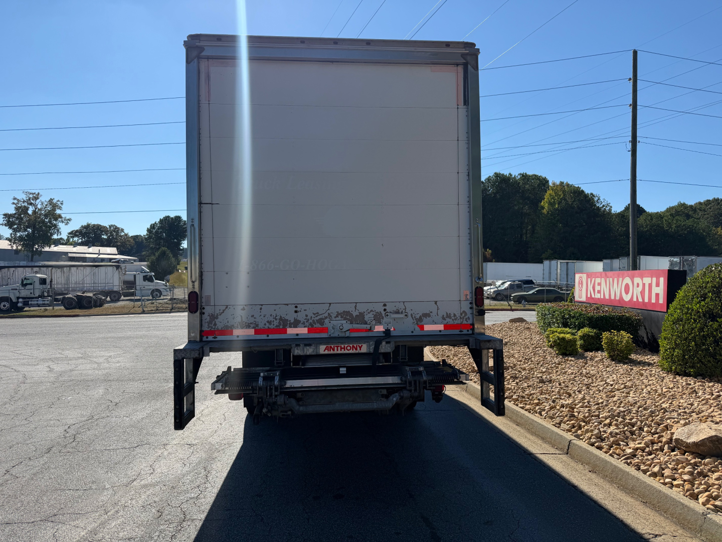 Rear view of a used 2022 International MV607 box truck showing the rear doors, bumper with taillights, and bumper steps.
