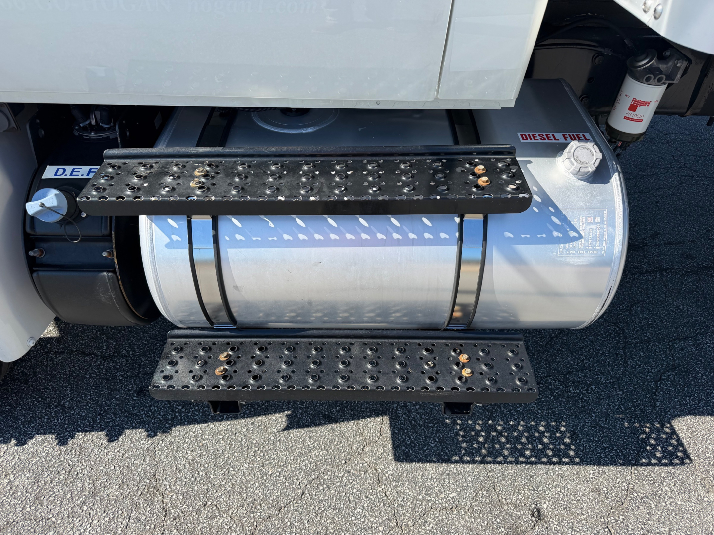 Tank and steps on side of truck with fuel tank and side steps showing fuel cap and ladders.