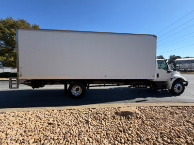 International MV607 box truck side view with white cargo box and cab, stock number 0633514, VIN 3HAEUMML7NL681138 visible in listing.