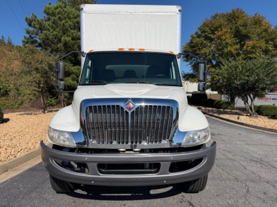 Front view of a 2022 International MV607 box truck with chrome grille, white cab, and large cargo box, daytime outdoor setting.