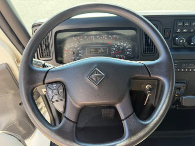 Steering wheel and instrument panel of a 2022 International MV607 truck showing gauges and dashboard controls.