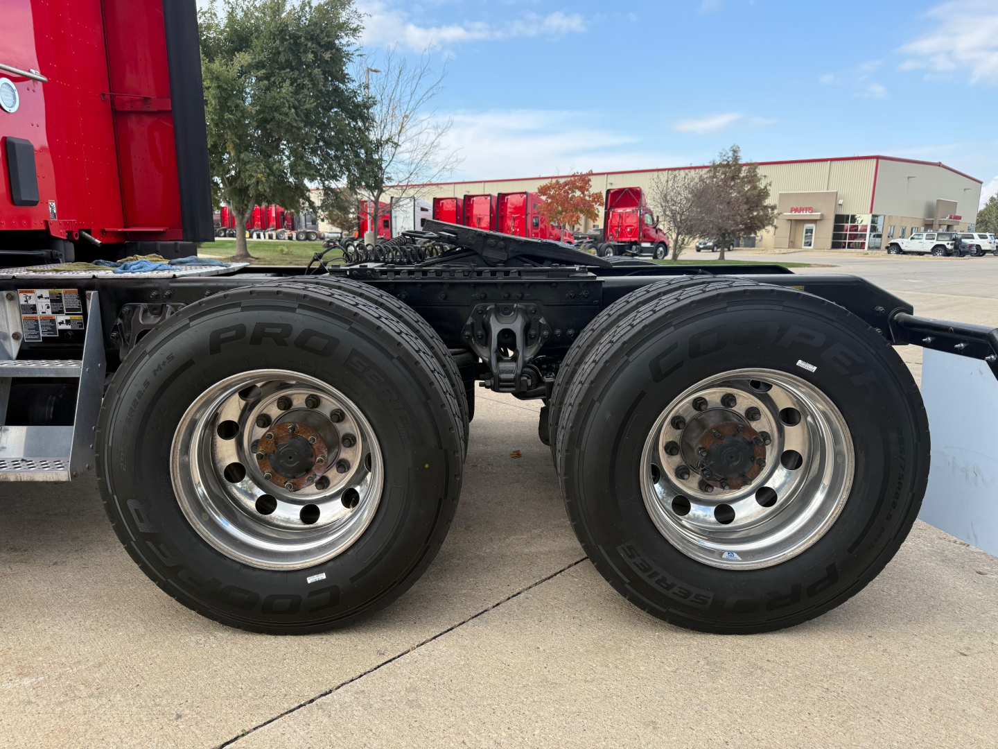 Kenworth T680 dual rear axles showing wheels and tires, chrome rims, part of chassis, no visible text on components.