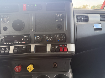 Kenworth T680 dashboard with controls, vents, and knobs visible; dashboard switches, climate controls, and a circular gauge area shown.