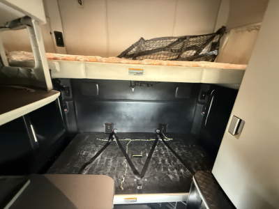 Kenworth T680 sleeper cab interior cargo area showing storage compartments and tiedown anchors in the rear area.