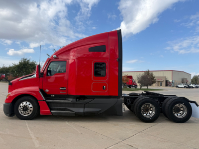 Kenworth T680 conventional sleeper truck side view showing red cab and rear axles.