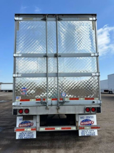 Rear view of a 2016 utility refrigerated trailer with diamond plate aluminum doors and taillights.