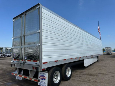 Utility reefer trailer side and rear view showing aluminum panel walls, tandem axles, rear doors, and reflective tape.