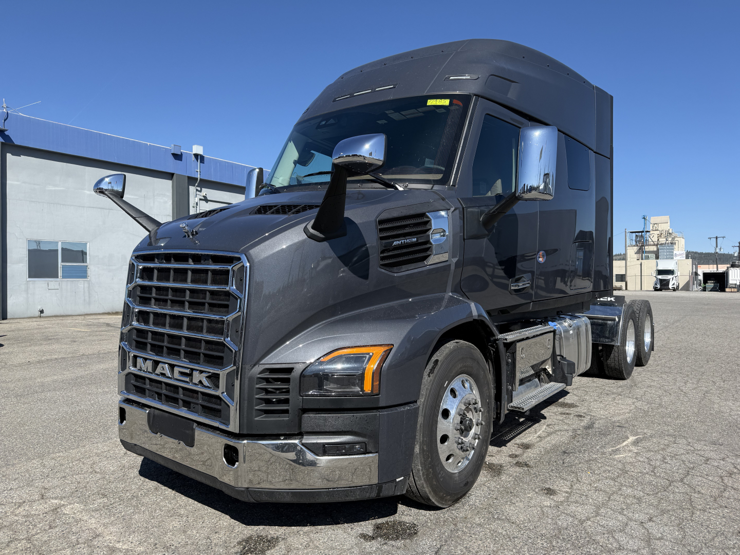 Mack AN64T64 conventional sleeper truck in new condition showing front grille, side mirrors, and cab with dark gray paint.
