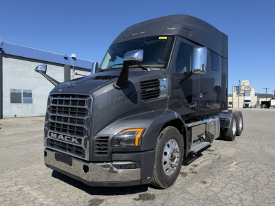 Mack AN64T64 conventional sleeper truck in new condition showing front grille, side mirrors, and cab with dark gray paint.
